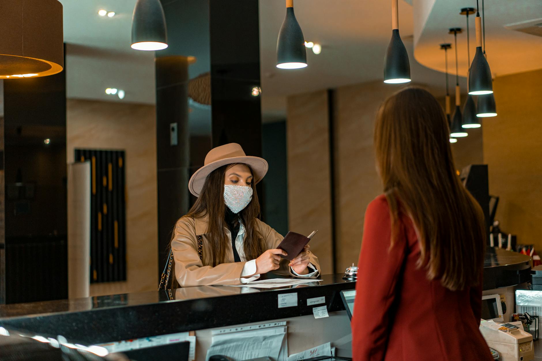 Kobieta w maseczce melduje się w recepcji hotelu w Meksyku