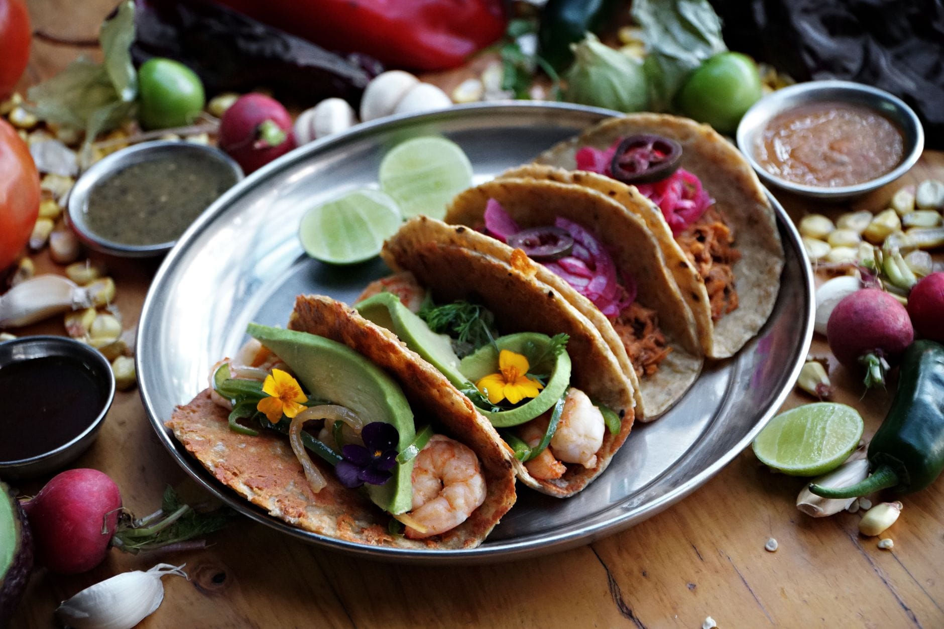 Kolorowe meksykańskie tacos z różnymi farszami na drewnianym stole