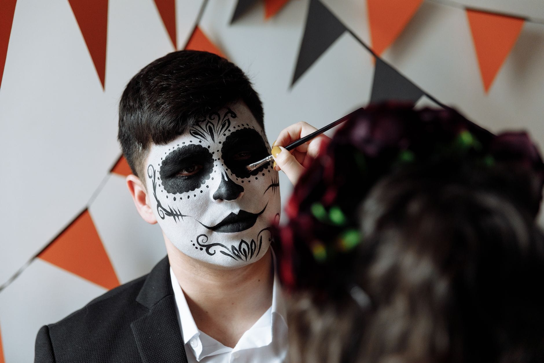 Mężczyzna podczas malowania twarzy na festiwal Dia de los Muertos