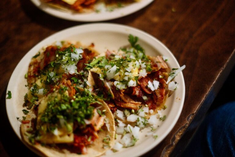 Meksykańskie tacos z kolendrą i cebulą na ceramicznym talerzu